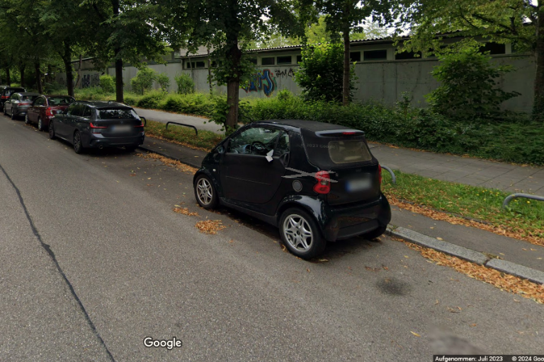 Strasse mit Autos und am rechten Strassenrand eine Wand, die gestaltet werden soll