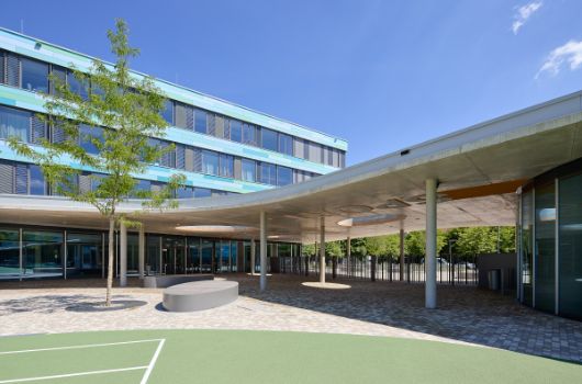 Das Dach über dem Erdgeschoss verbindet die Schule mit der Sporthalle und bietet einen überdachten Übergang 
