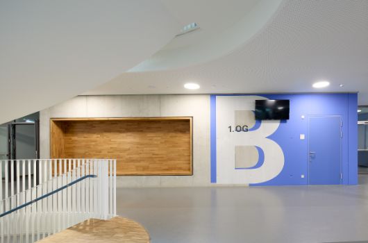 Wandgestaltung im Bereich der Haupttreppe mit Sitznische und Signaletik