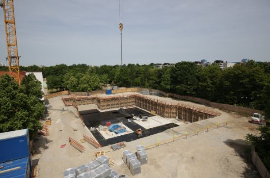 Die Baugrube ist ausgehoben, erste Umrisse des Kellers sind erkennbar.