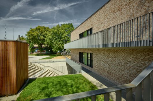 Westfassade Neubau mit Atriumtreppe in den Tiefhof zur Mensa und Anlieferungsgebäude der Küche