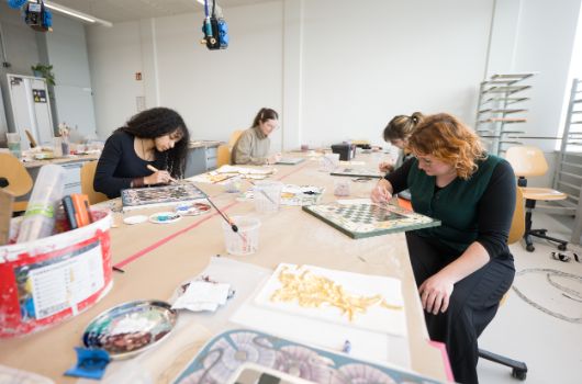 Schülerinnen beim Holz bemalen