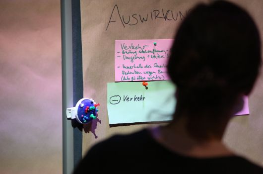 Eine Teilnehmerin der Planungszellen steht vor einer Pinnwand.