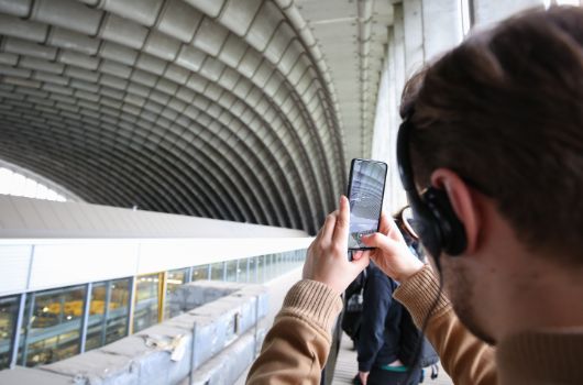 Ein Teilnehmer der Planungszellen macht ein Handy-Foto im Inneren der Paketposthalle