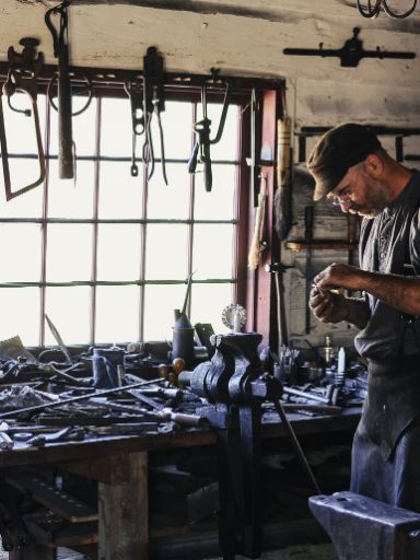 Mann in seiner Werkstatt mit vielen verschiedenen Werkzeugen