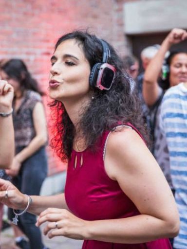 Frau mit Kopfhörern tanzt.