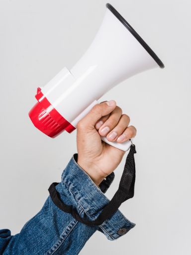 Hand hält ein Megaphon. 