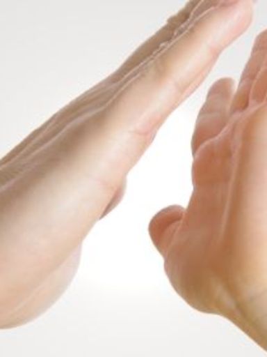 Frauenhand und Kinderhand klatschen sich ab