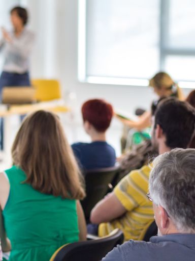 Erwachsene sitzen im Unterricht.