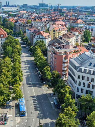 Eine belebte Münchner Straße von oben mit der Frauenkirche im Hintergrund
