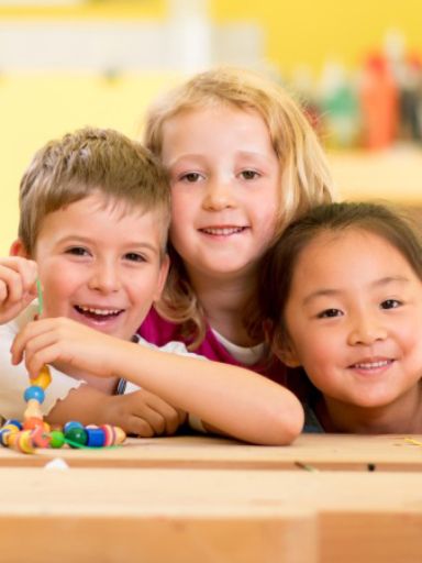 Drei Kinder in der Kita am Basteltisch