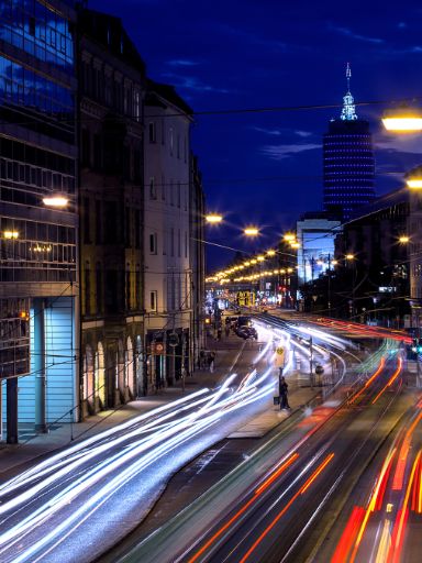 Beleuchtete und belebte Straße bei Nacht