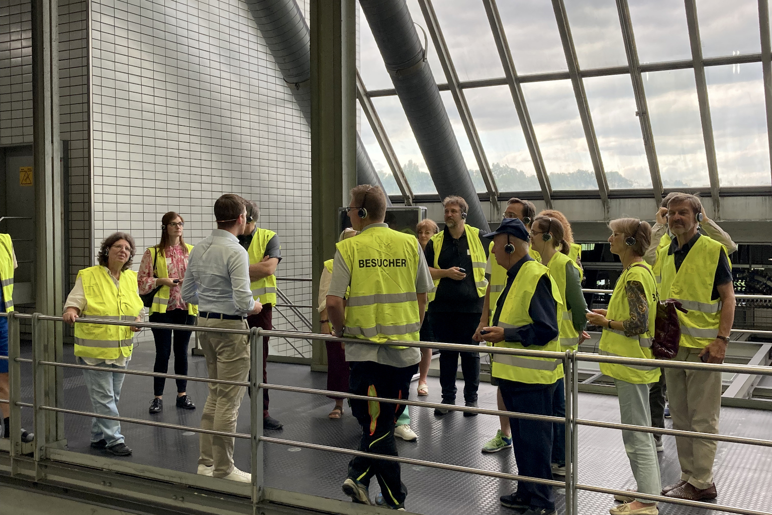 Gruppe in Warnweste vor Fensterfront